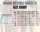 Lokelani Dark shorts with Palaka print, modeled outdoors. Model's hand on the hip, with others in background. Bright lighting.