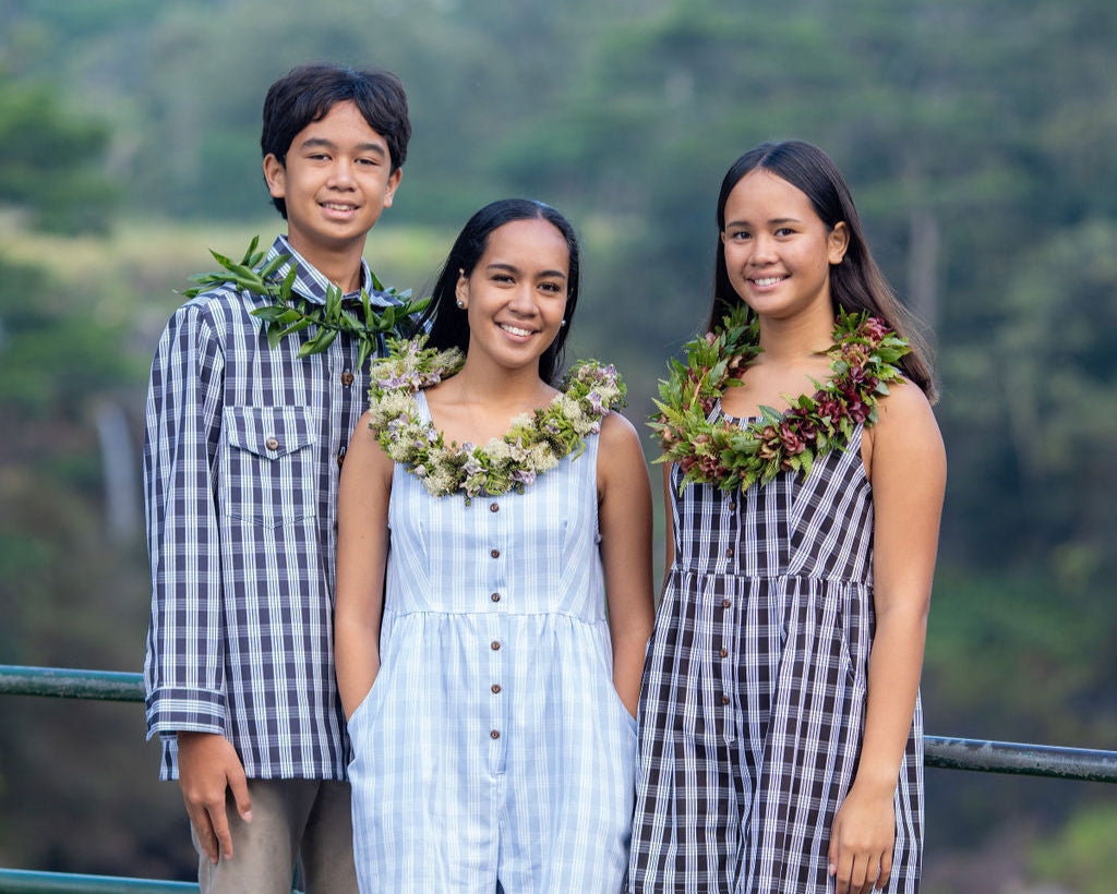 3 models in KAHUI Palaka apparel. Male in an Aloha Shirt, and two females in jumpsuits. 