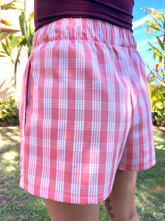 Wahine Holoholo Shorts 2.0 with a traditional Palaka pattern in a sunny outdoor setting. Elastic waist, side view, and bright lighting.